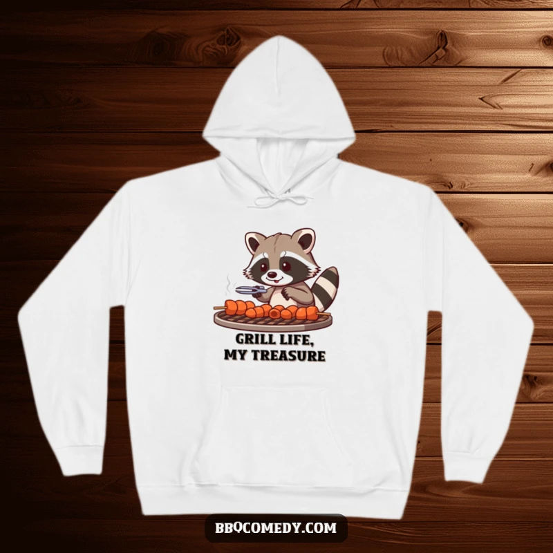 Playful raccoon with tongs arranging skewers on a grill grate, cozying up in this funny hoodie.